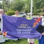 James and Chisako hold the AAPI Heritage Month flag prior to it being raised on the flagpole.